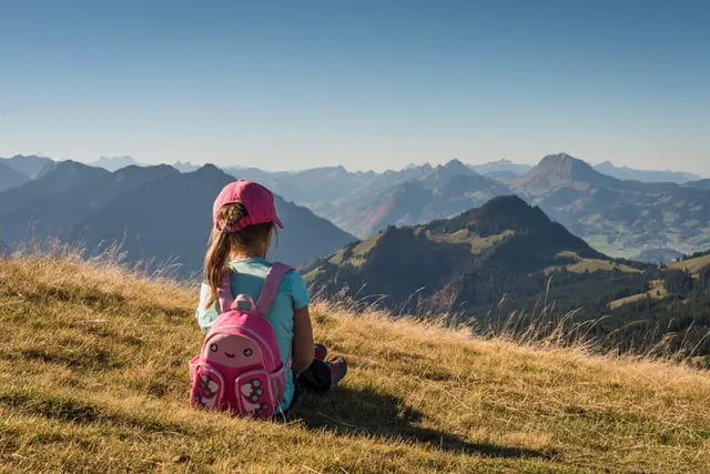 young girl wearing pink backpack
