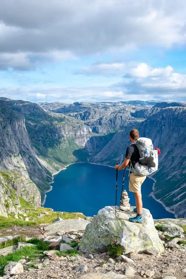 man wearing a backpack and holding trekking poles