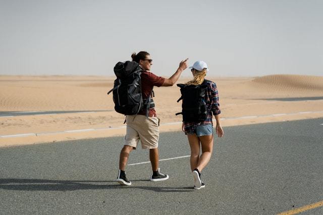 two backpackers walking on a road