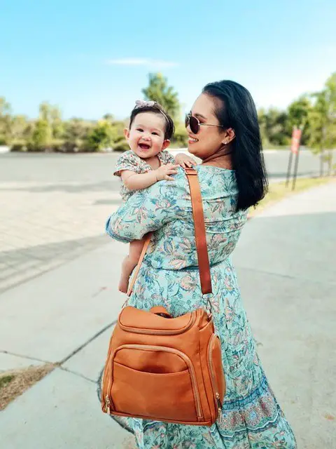 mother and daughter carrying a diaper bag